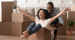 Happy african young couple riding in box on moving day